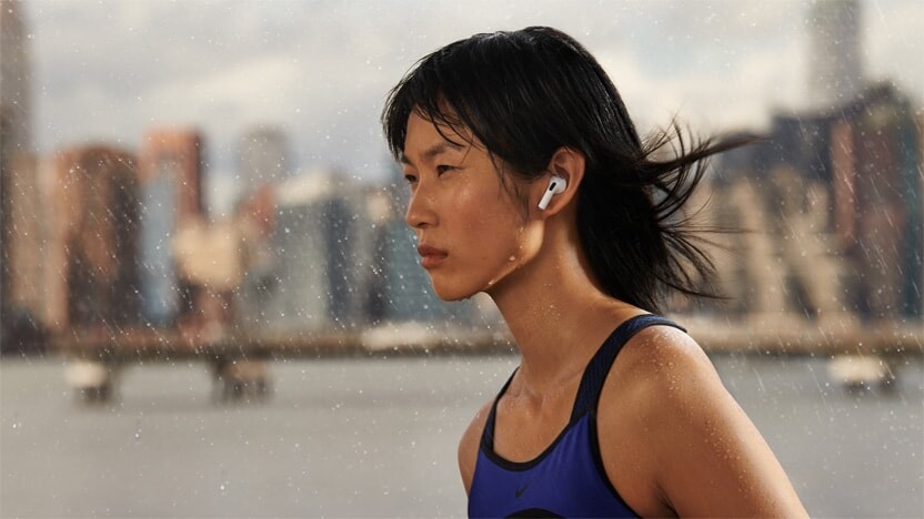 A woman wearing AirPods (3rd generation) in the rain