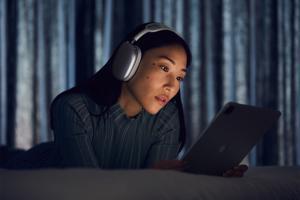 Woman using AirPods Max with iPad Pro.  