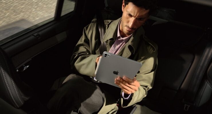 A passenger in the back of a car looks at the new iPad Pro with M5 on the go.